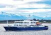 A cruise ship sailing in front of snow-capped mountains