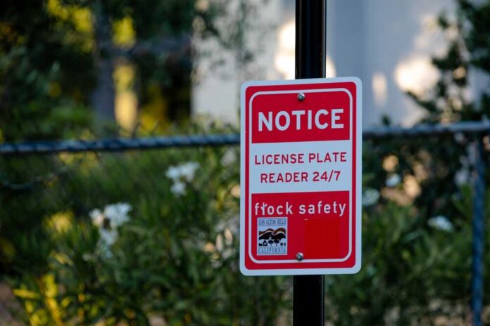 Red notice sign on a pole in a leafy suburban area