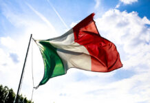 Heatwave INFERNO – Italy’s Emergency Alert Unleashed! Italian flag waving against a blue sky