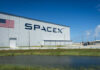 SpaceX building with American flag sky background