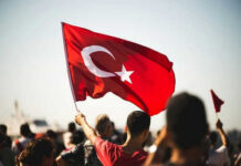 Gaza Flotilla Showdown: Turkey’s Bold Airlift Move Person waving Turkish flag in a crowd