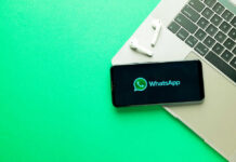 WhatsApp Privacy PROMISES FAILED? Texas to Uncover Truth Smartphone on laptop with WhatsApp displayed alongside earbuds