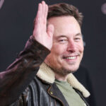 Roasted: Musk Blasts ‘Liar’ Lawmaker Man in leather jacket smiling and waving