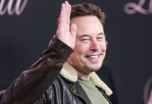 Roasted: Musk Blasts ‘Liar’ Lawmaker Man in leather jacket smiling and waving