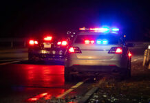 Deadly Stop Sparks New Courtyard Rules Police car with flashing lights parked on the roadside at night