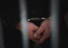 Border Vetting Backlash Explodes In Belfast Close-up of handcuffed hands behind bars