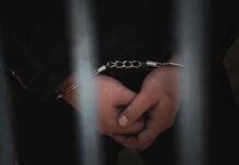 Border Vetting Backlash Explodes In Belfast Close-up of handcuffed hands behind bars