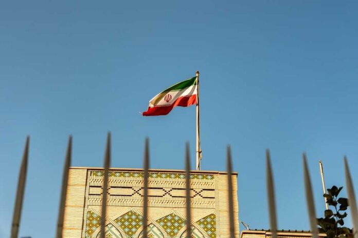 Iranian,Embassy,In,Qatar,,Doha.,The,Concept,Of,Sanctions,Pressure Iranian flag waving above a government building against a blue sky