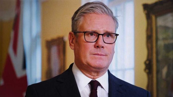 Keir,Starmer,,Wearing,Glasses,And,A,Suit,,Looks,Directly,At A man in formal attire with glasses, looking serious in an indoor setting