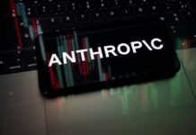 Europe Presses Mythos Access—Anthropic Plays Gatekeeper Smartphone displaying the word 'ANTHROPIC' over a background of financial graphs