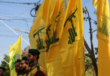 Ceasefire Deal Supercharges Hezbollah? Men standing with yellow flags wearing green berets