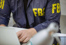 FBI agent working on laptop indoors