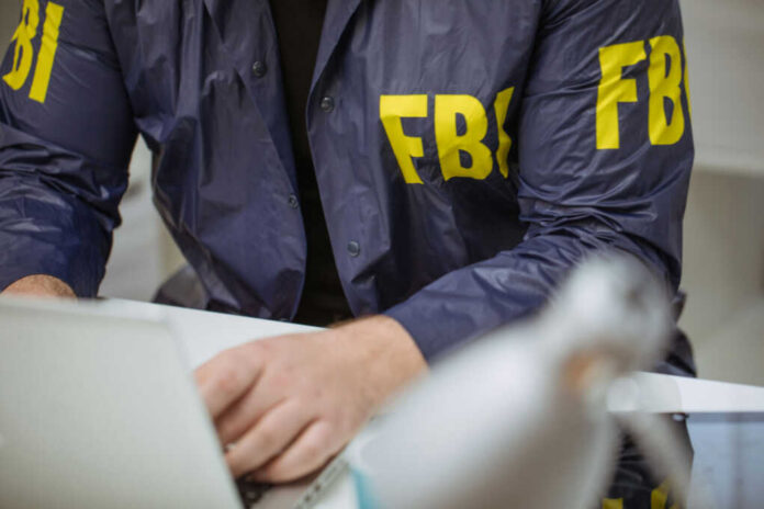 FBI agent working on laptop indoors