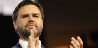 Man in suit clapping at an event