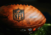 NFL Paywall Backlash Explodes — DOJ Steps In Close-up of an NFL football on grass.