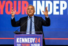 Man speaking at podium with Kennedy24 campaign sign.