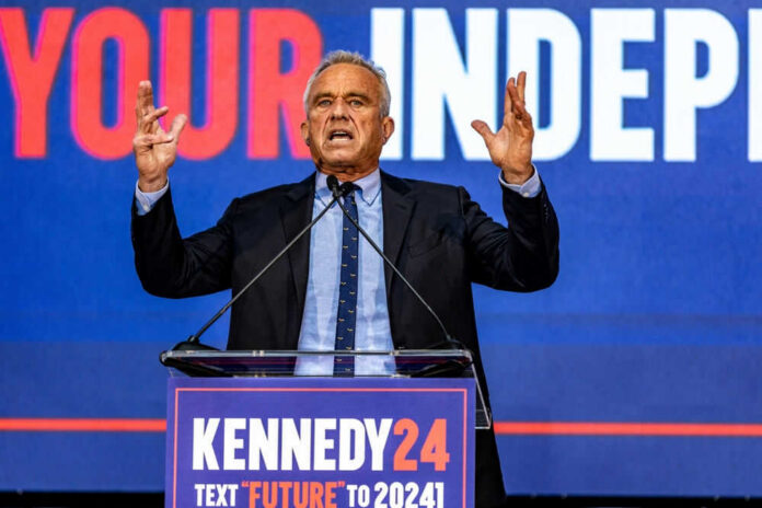 Man speaking at podium with Kennedy24 campaign sign.