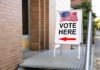 Sidewalk sign with American flag directing to a polling place