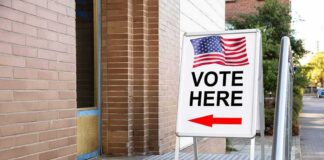 Sidewalk sign with American flag directing to a polling place