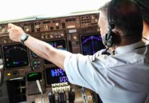 Pilot’s Livelihood Threatened Over Beer Pilot adjusting controls in an airplane cockpit