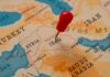 Troops Out… Except Where It Matters A map of the Middle East with a red pin marking Iraq
