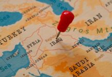 Troops Out… Except Where It Matters A map of the Middle East with a red pin marking Iraq