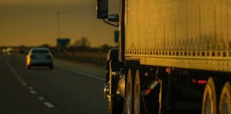 Semi-truck trailer driving on highway at sunset