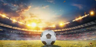 Soccer ball on stadium field at sunset