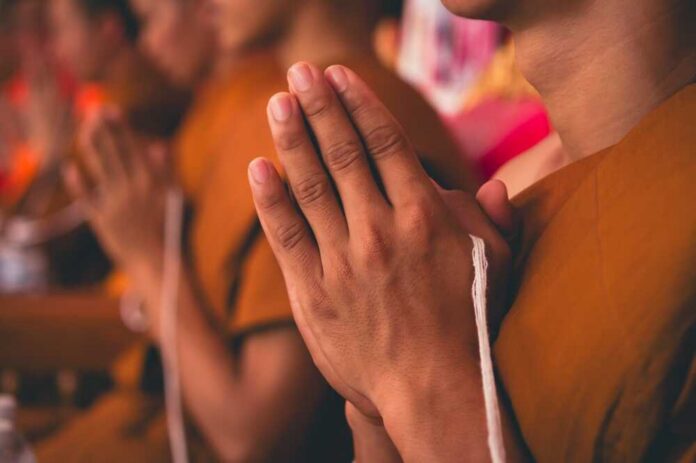 Close-up,Of,Monks,Performing,Religious,Ceremonies,With,White,Sacred,Thread Monks with hands clasped in prayer during a ceremony