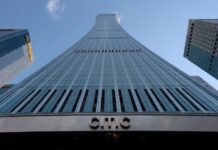 Suicide Story, Zero Evidence — Beijing Stonewalls Curved glass skyscraper viewed from below against a clear blue sky