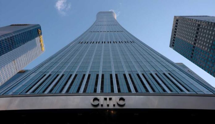 Curved glass skyscraper viewed from below against a clear blue sky