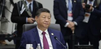 Senior official in a blue suit sits at an international conference table