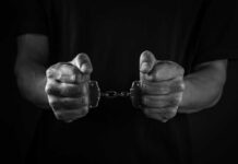 ISIS Plot Foiled at BWI — What Was Plan B? Hands holding handcuffs in a black and white image