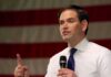 Rubio Draws Line — Not Our War Anymore man speaking with microphone in front of an American flag