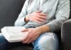 Person holding takeout container while touching stomach
