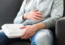 Person holding takeout container while touching stomach