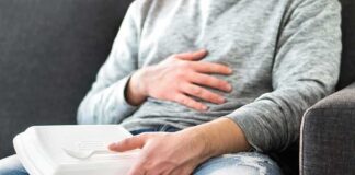 Person holding takeout container while touching stomach