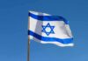Israeli flag waving against a clear blue sky