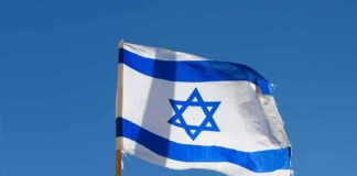 Israeli flag waving against a clear blue sky