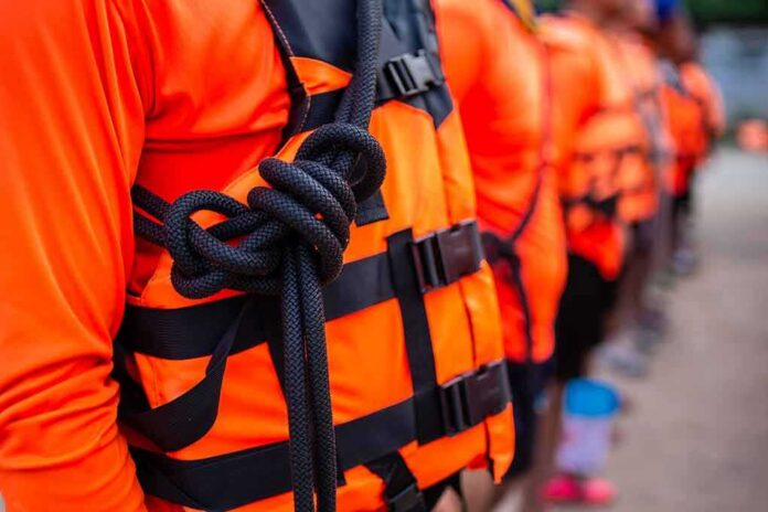Life jacket with rope knot in a line of people