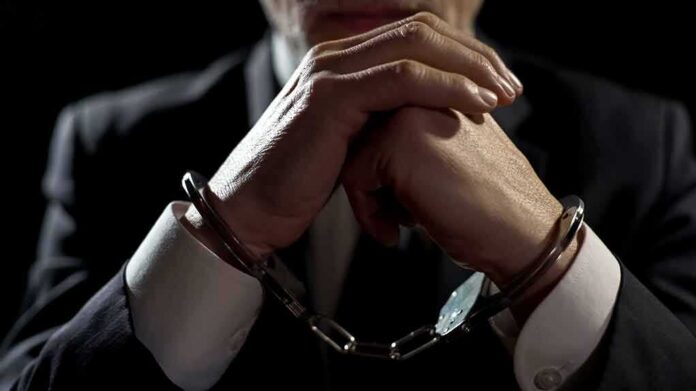 shutterstock_1068932513 Businessperson in handcuffs with hands clasped