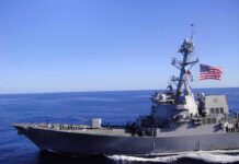 Dad’s Shocking “Take Me Instead” Plea Naval destroyer sailing on open sea with flag flying