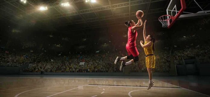 Two basketball players contest a layup under the hoop
