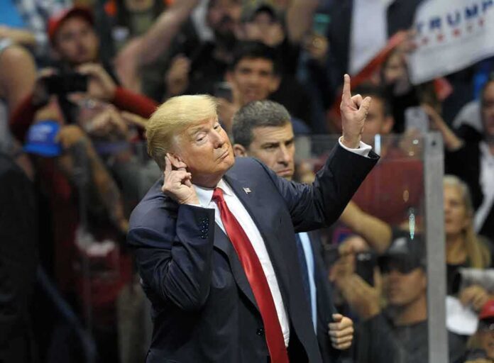 shutterstock_1427778506 man in suit gestures with raised finger at a crowded event