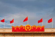 China’s Watchtower Goes Global — 80+ And Counting Chinese flags atop a decorated building facade