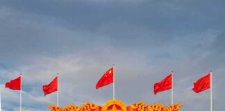 Chinese flags atop a decorated building facade