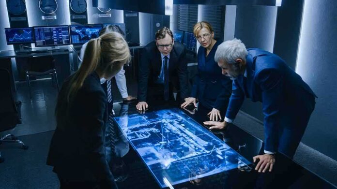 shutterstock_1506802679 Business team reviewing a glowing digital map table