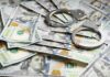 Handcuffs on scattered US hundred dollar bills