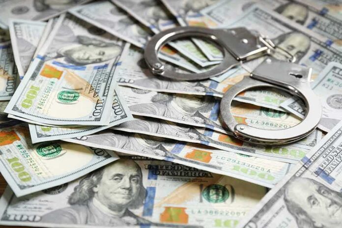 Handcuffs on scattered US hundred dollar bills