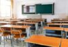Empty classroom with rows of desks and a chalkboard